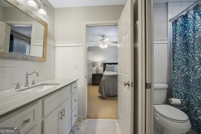 a en suite bathroom with a granite countertop sink and a mirror