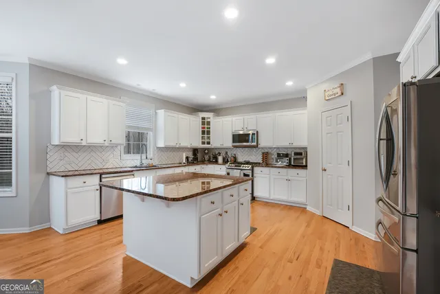 a kitchen with white cabinets and stainless steel appliances