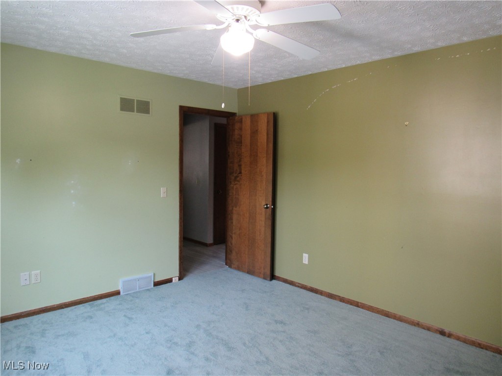 1120 Vincent Road Southeast North Canton, OH 44720 - Photo 36 of 50 Middle Bedroom new carpet, a textured ceiling, and ceiling fan