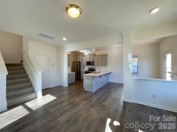 a large kitchen with cabinets wooden floor and a sink