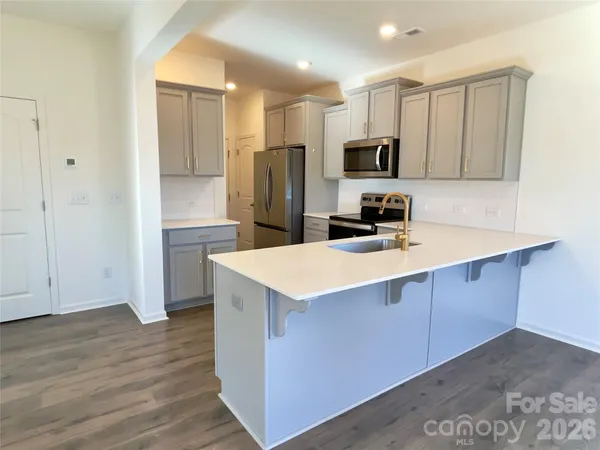 a kitchen with stainless steel appliances a sink a stove a refrigerator and cabinets