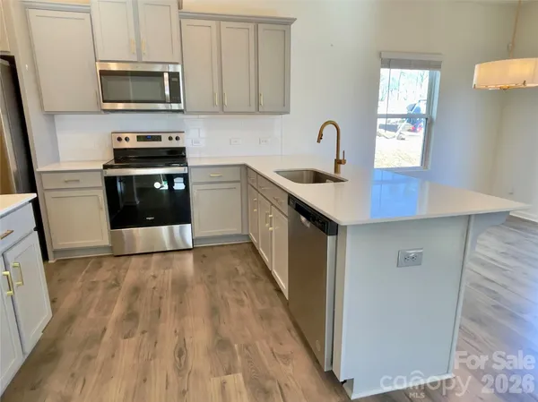 a kitchen with granite countertop a sink and a stove top oven