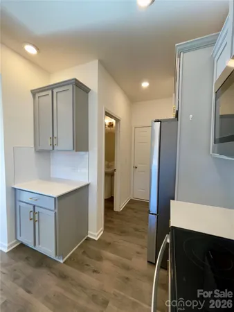 a kitchen with stainless steel appliances cabinets and wooden floor