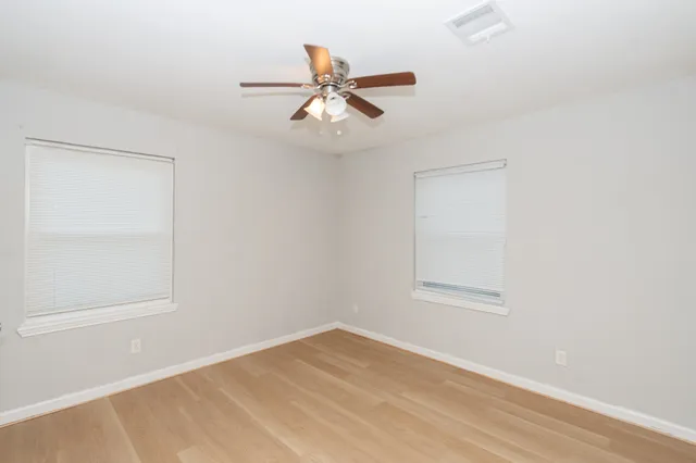 an empty room with a window and a fan