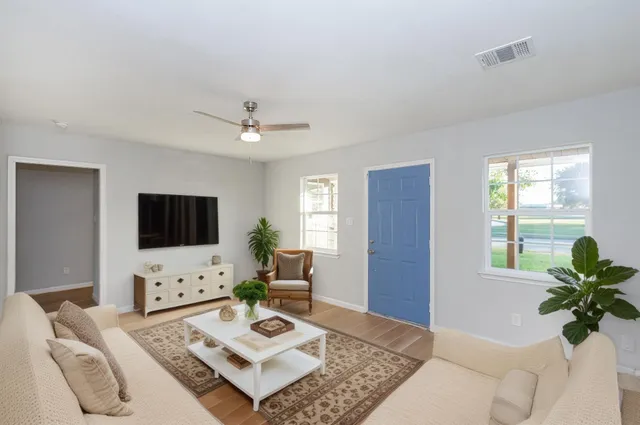 a living room with furniture a flat screen tv and a large window