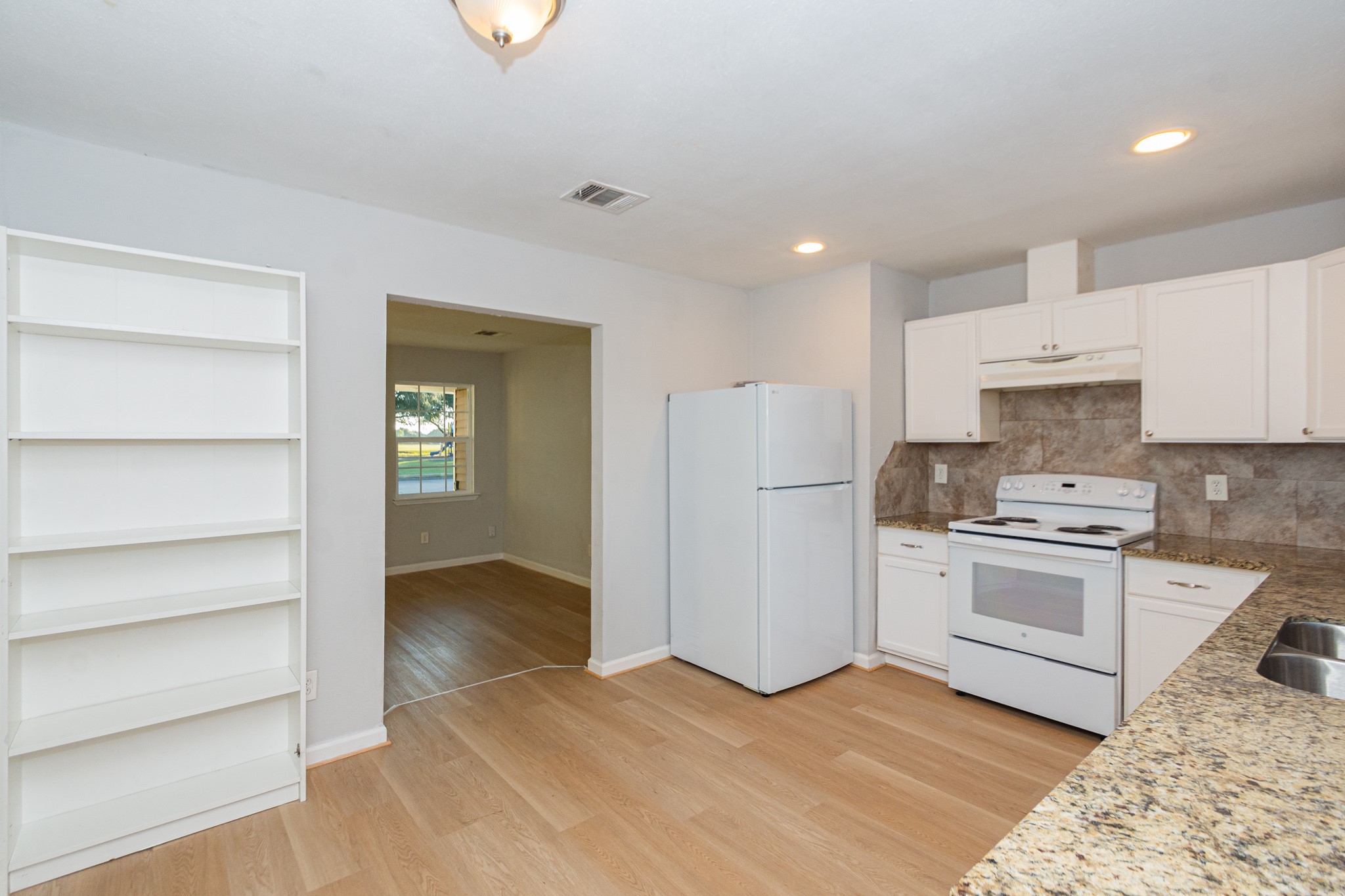 3707 Meadowlake Road Pasadena, TX 77503 - Photo 8 of 32 a kitchen with a refrigerator stove and white cabinets