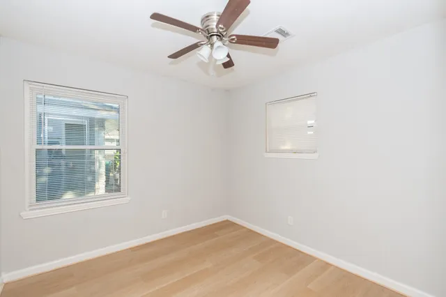 an empty room with a window and a fan