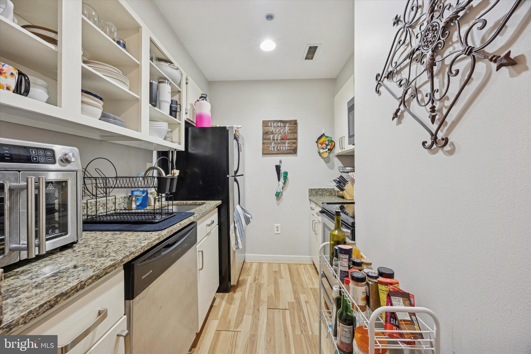 315 New Street, Unit 111 Philadelphia, PA 19106 - Photo 12 of 19 a kitchen view of a kitchen island with stainless steel appliances granite countertop lots of clutter