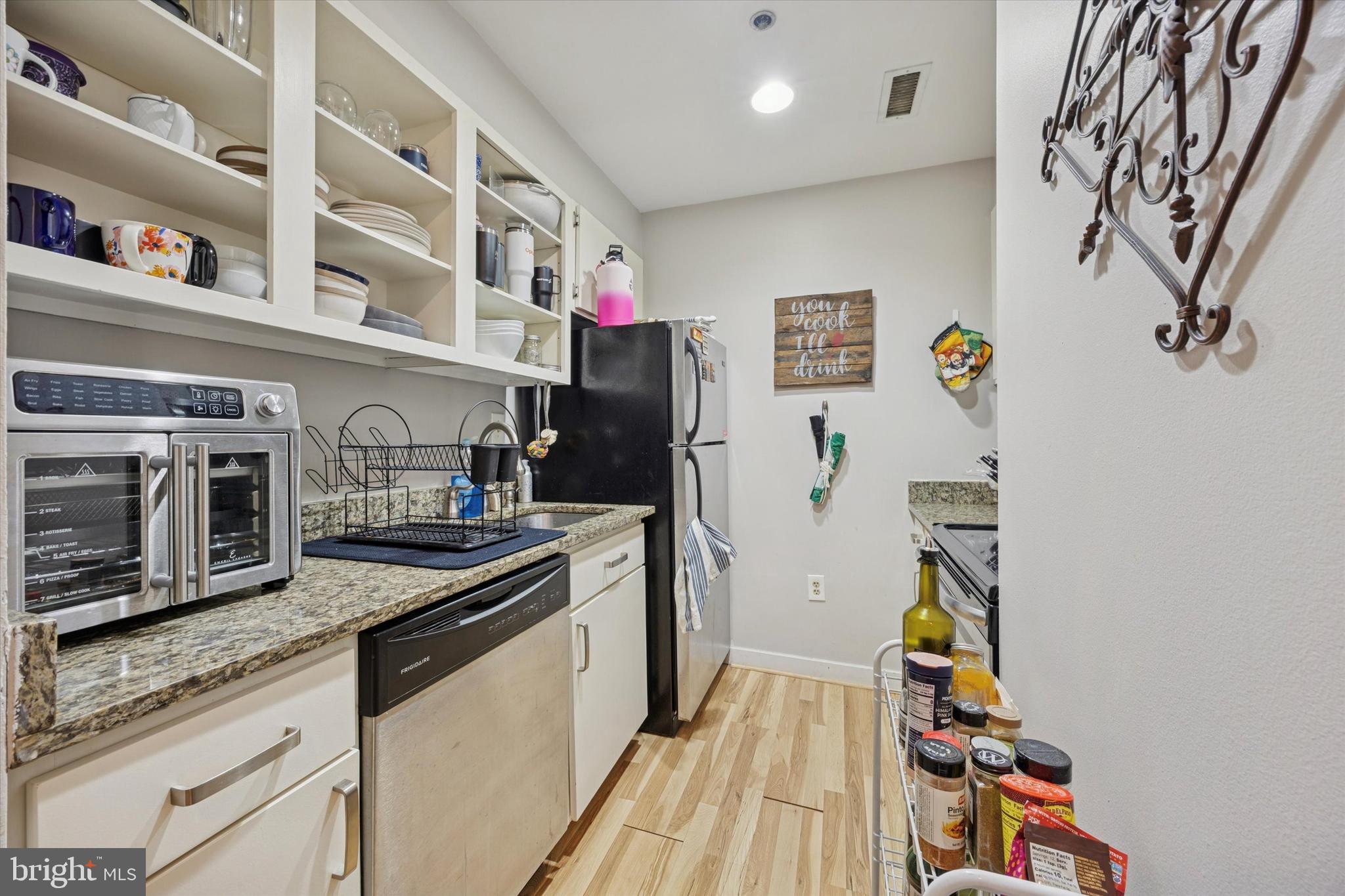 315 New Street, Unit 111 Philadelphia, PA 19106 - Photo 9 of 19 a kitchen with stainless steel appliances granite countertop a refrigerator and a stove top oven
