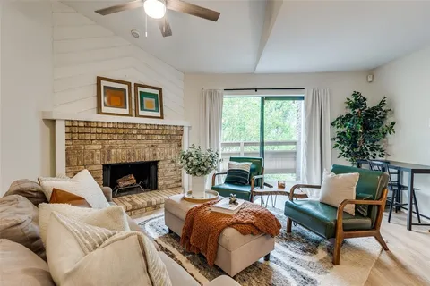 a living room with furniture fireplace and large windows