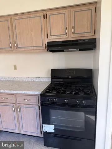 a stove top oven sitting inside of a kitchen