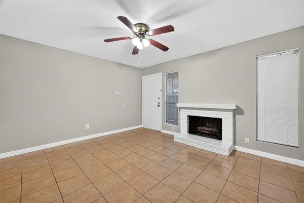 an empty room with fireplace and fan