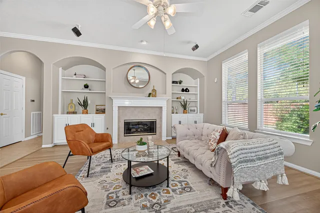 a living room with furniture a fireplace and a large window