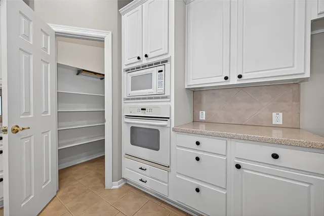 a kitchen with white cabinets and white appliances