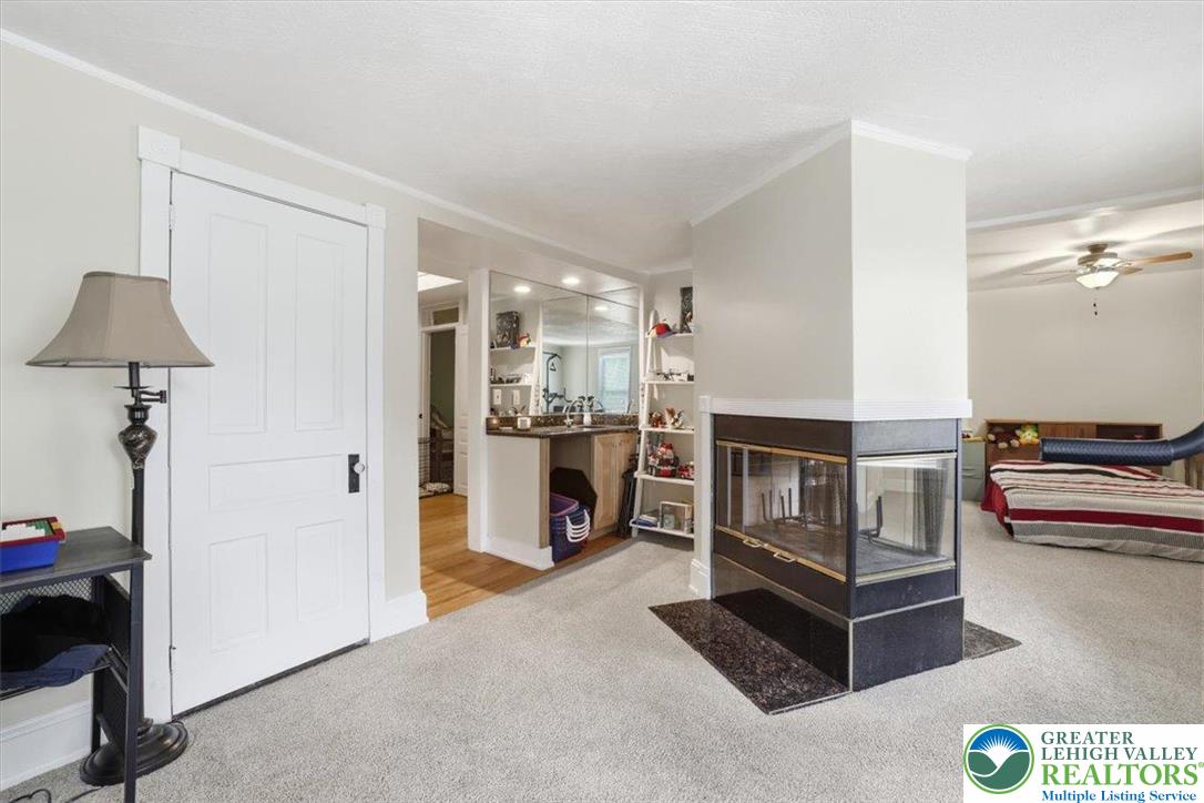 3585 Fairyland Road Lehighton, PA 18235 - Photo 45 of 57 A striking glass-enclosed fireplace anchors this versatile living area, complemented by a convenient wet bar.