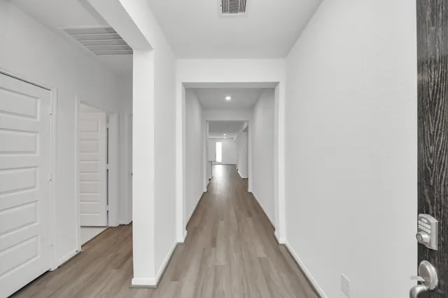 a view of a hallway with wooden floor