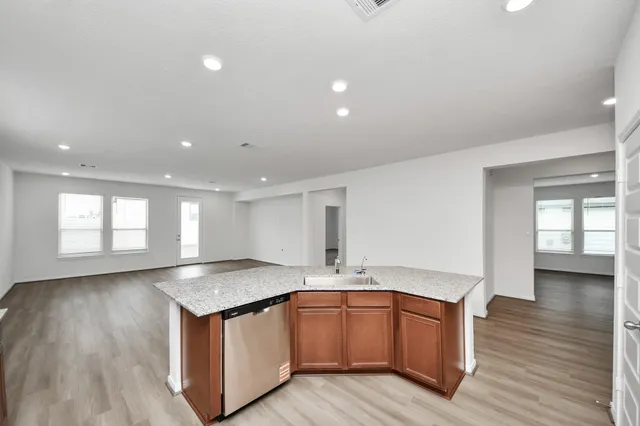 a kitchen with granite countertop a sink and wooden floor