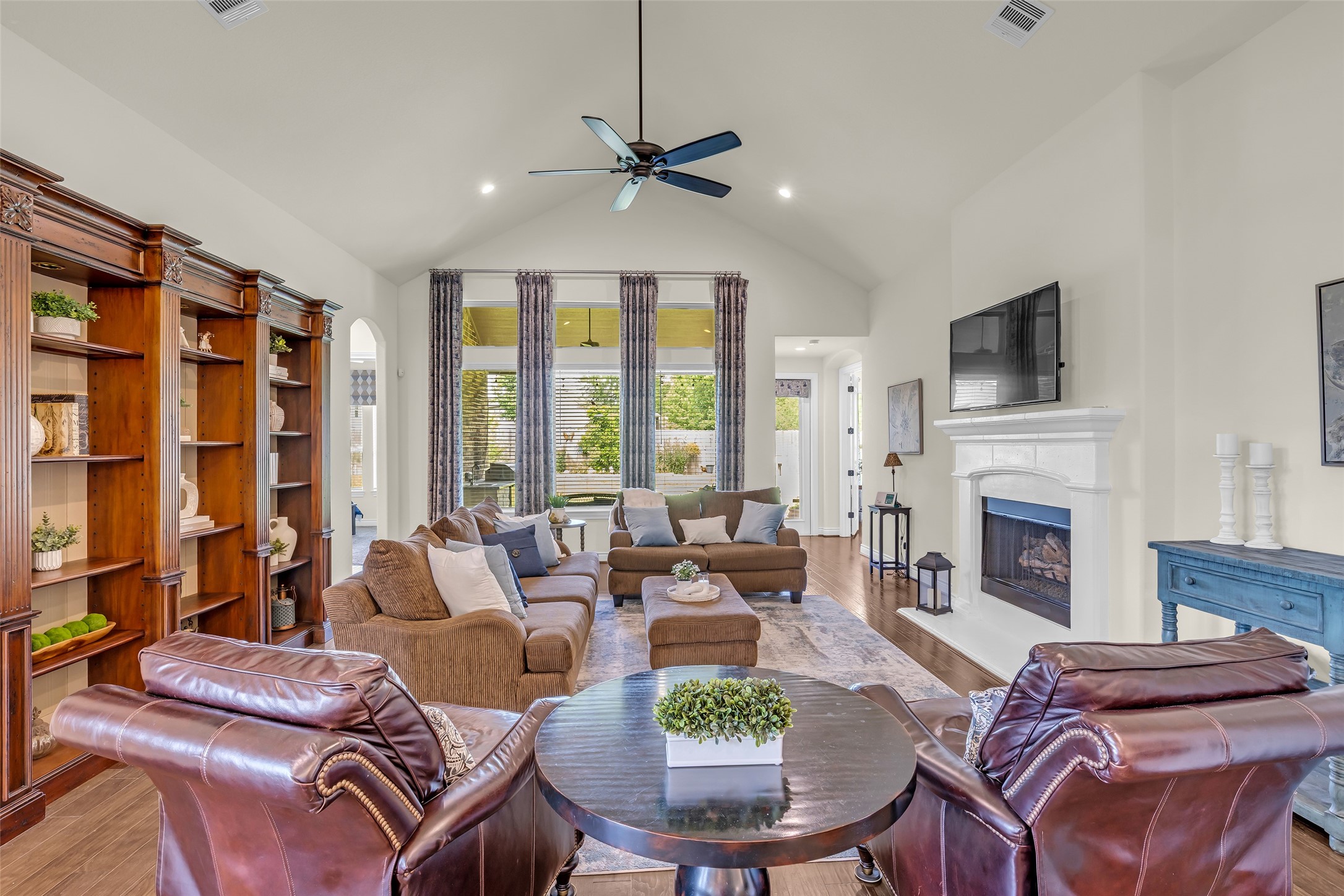 14003 South Evergreen Ridge Court Conroe, TX 77384 - Photo 14 of 43 Vaulted ceilings, a wall of windows, and floor-to-ceiling custom draperies fill the family room with natural light and backyard views.