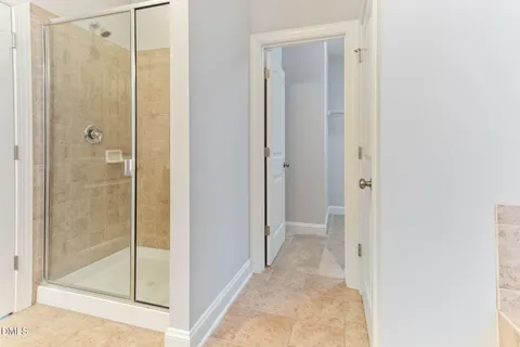 an empty room with a chandelier fan and windows