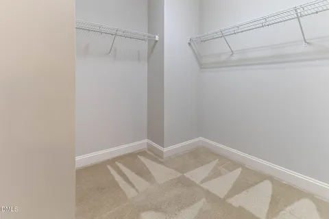 an empty room with chandelier fan and closet area