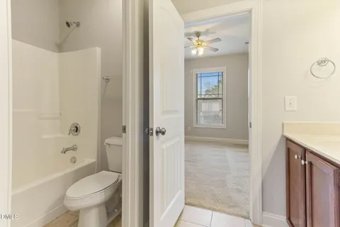 a view of an empty room with closet and a window