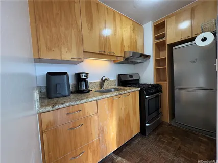 a kitchen with stainless steel appliances granite countertop a refrigerator sink and cabinets
