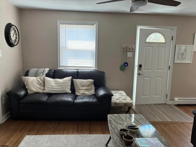 a living room with furniture and wooden floor