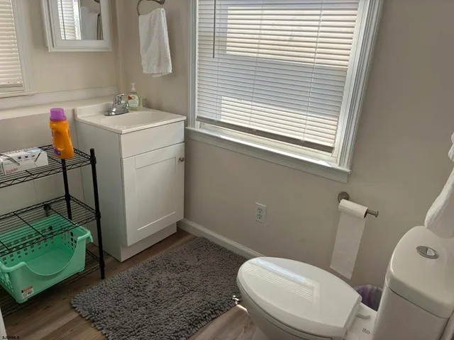 a bathroom with a sink toilet and window