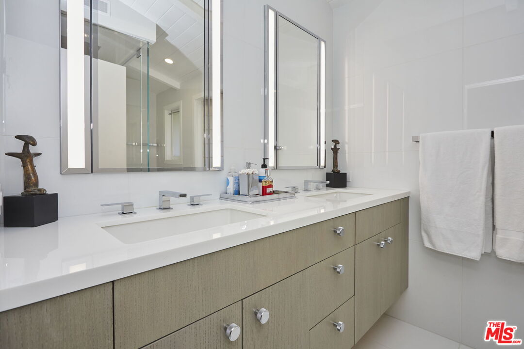 9428 Lloydcrest Drive Beverly Hills, CA 90210 - Photo 11 of 36 a bathroom with a double vanity sink and mirror