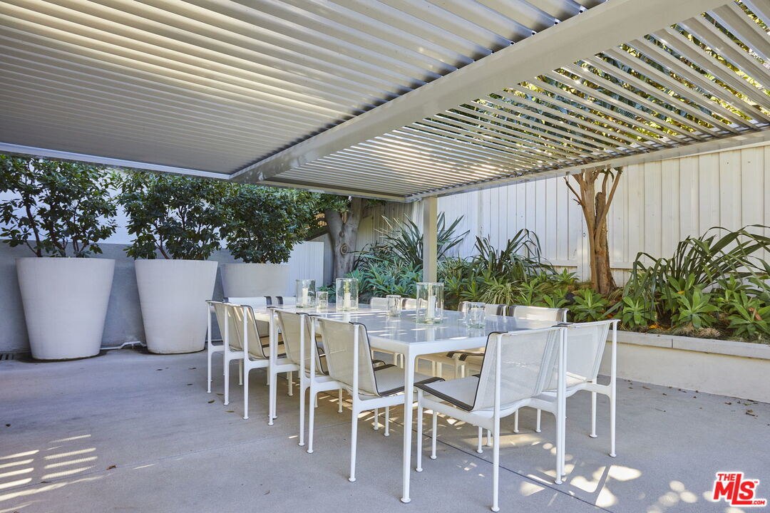9428 Lloydcrest Drive Beverly Hills, CA 90210 - Photo 19 of 36 a view of a patio with table and chairs and potted plants