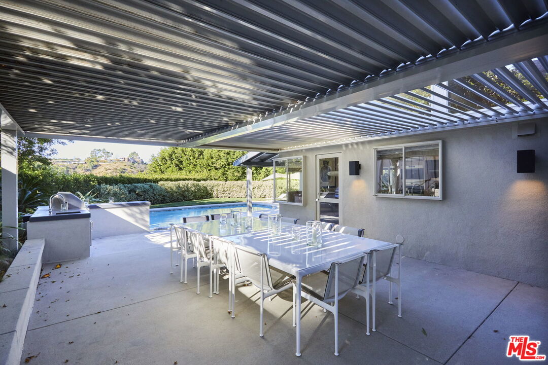 9428 Lloydcrest Drive Beverly Hills, CA 90210 - Photo 20 of 36 a view of a patio with a table and chairs and a barbeque