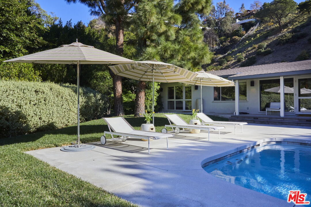 9428 Lloydcrest Drive Beverly Hills, CA 90210 - Photo 30 of 36 a view of pool with table and chairs under an umbrella