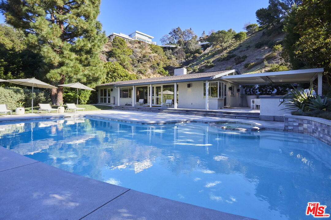 9428 Lloydcrest Drive Beverly Hills, CA 90210 - Photo 32 of 36 a front view of a house with swimming pool