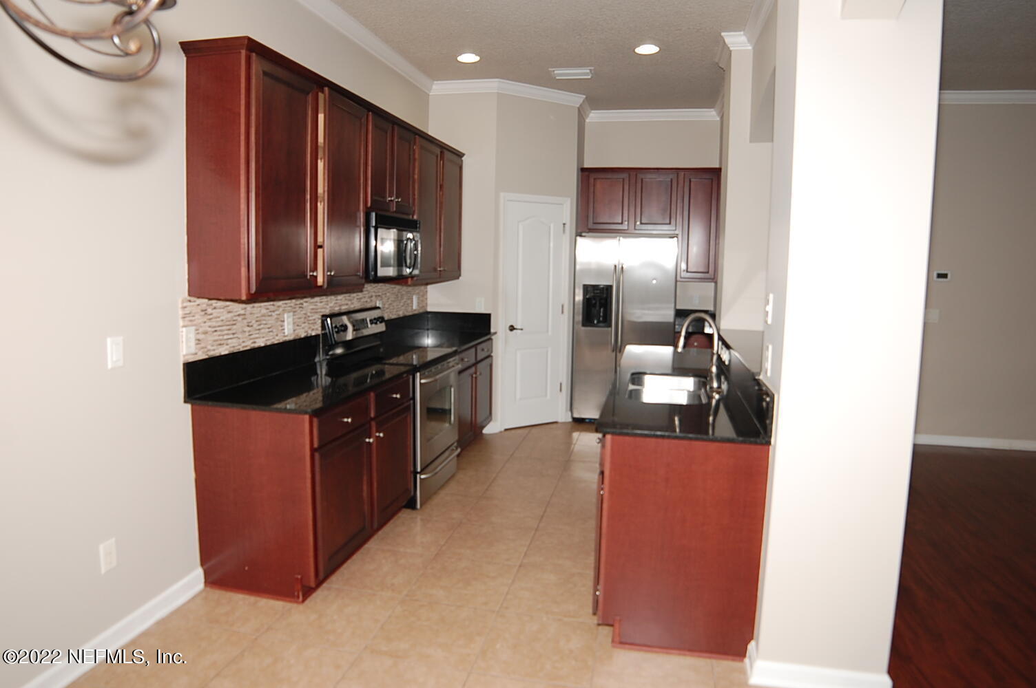 562 Candlebark Drive Jacksonville, FL 32225 - Photo 8 of 30 a kitchen with stainless steel appliances granite countertop wooden cabinets a stove top oven a sink and dishwasher