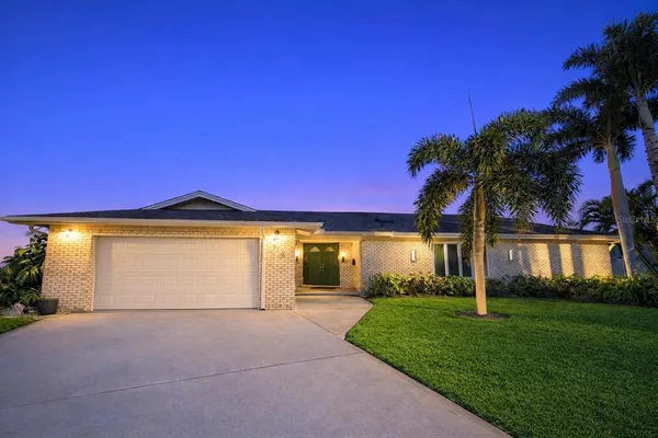 a front view of a house with a garden and yard