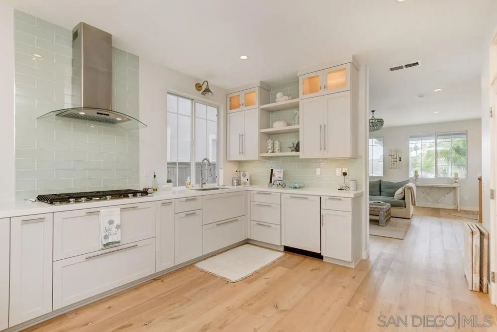 124 Breakwater Road Carlsbad, CA 92011 - Photo 4 of 20 a kitchen with white cabinets and sink