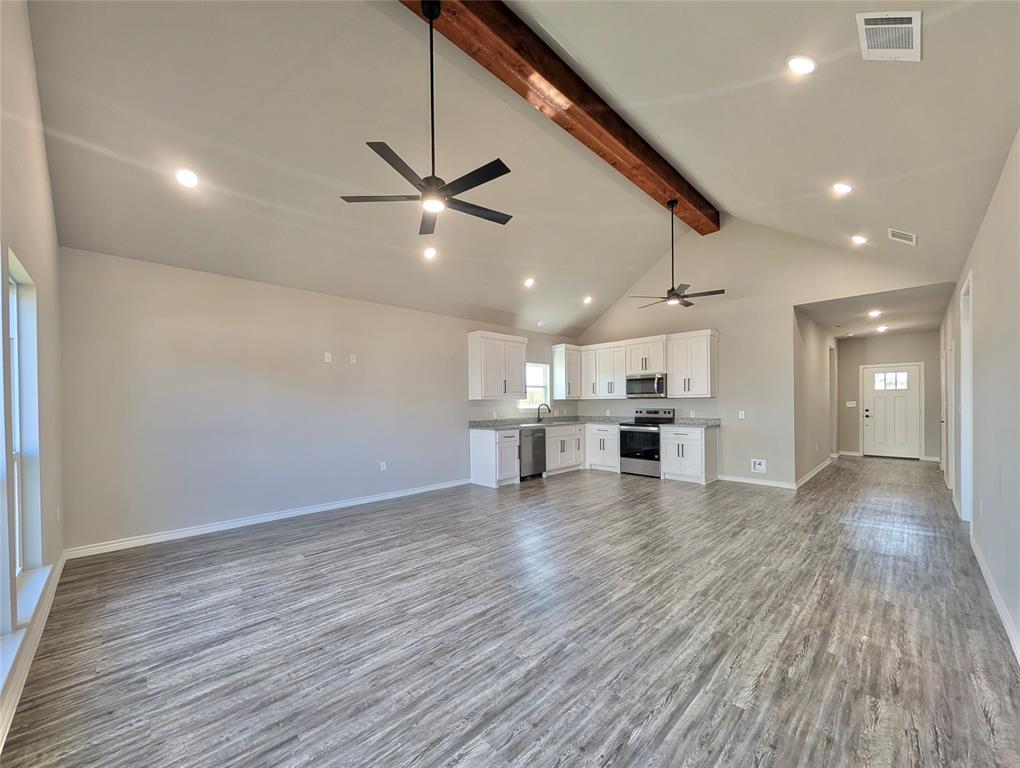 300 Rike Road Mabank, TX 75147 - Photo 5 of 18 a view of an empty room with wooden floor and a ceiling fan