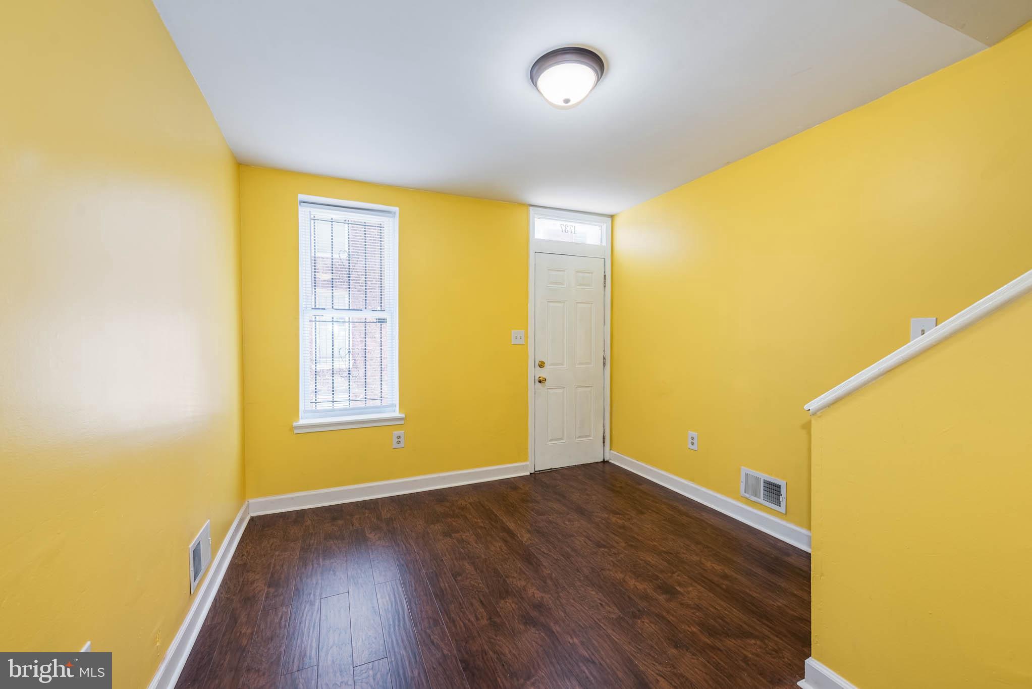 1737 North Dallas Street Baltimore, MD 21213 - Photo 2 of 14 a view of an empty room with wooden floor and a window