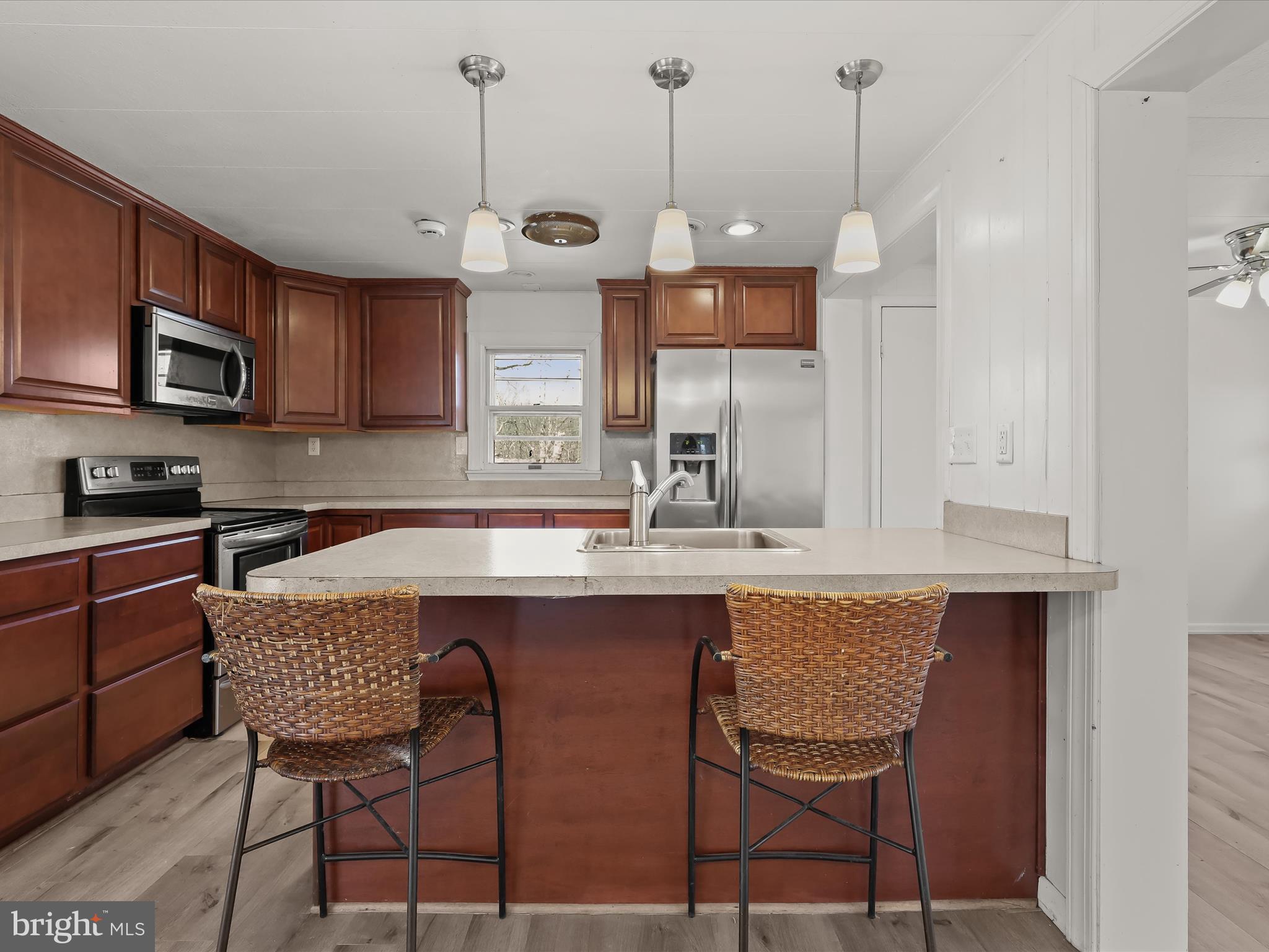 1970 Lower Marlboro Road Huntingtown, MD 20639 - Photo 20 of 81 a kitchen with stainless steel appliances granite countertop a sink a stove a microwave a dining table and chairs with wooden floor