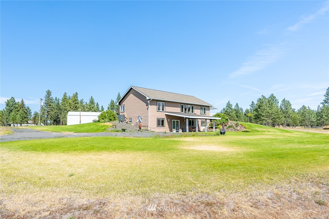 19922 South Smythe Road Spangle, WA 99031 - Photo 27 of 37 a front view of a house with a garden and lake view