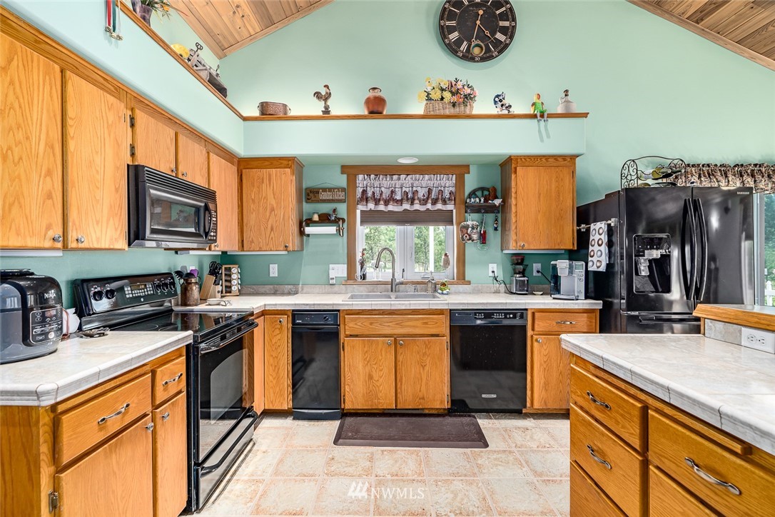 19922 South Smythe Road Spangle, WA 99031 - Photo 6 of 37 a kitchen with stainless steel appliances granite countertop a sink stove and cabinets