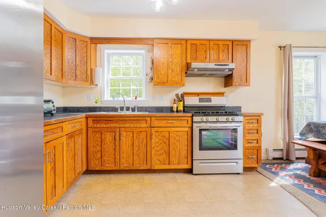 a kitchen with granite countertop a stove a sink and a cabinets