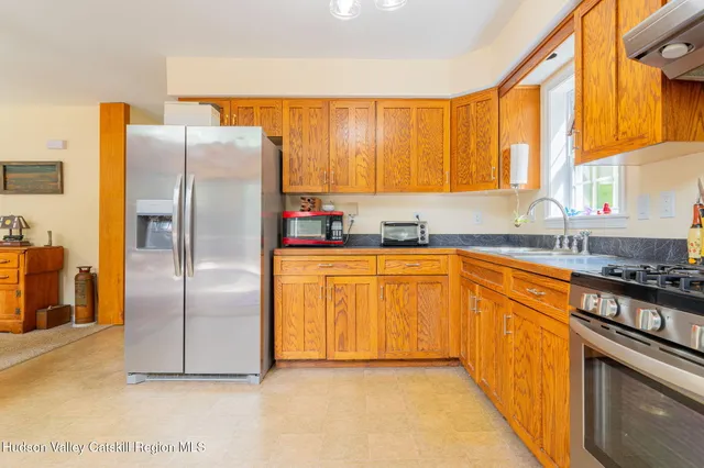 a kitchen with stainless steel appliances granite countertop a refrigerator a sink a stove top oven and a dishwasher