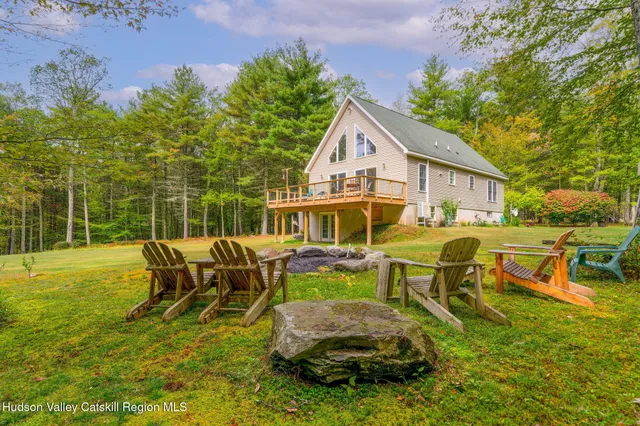 a view of a house with backyard and sitting area