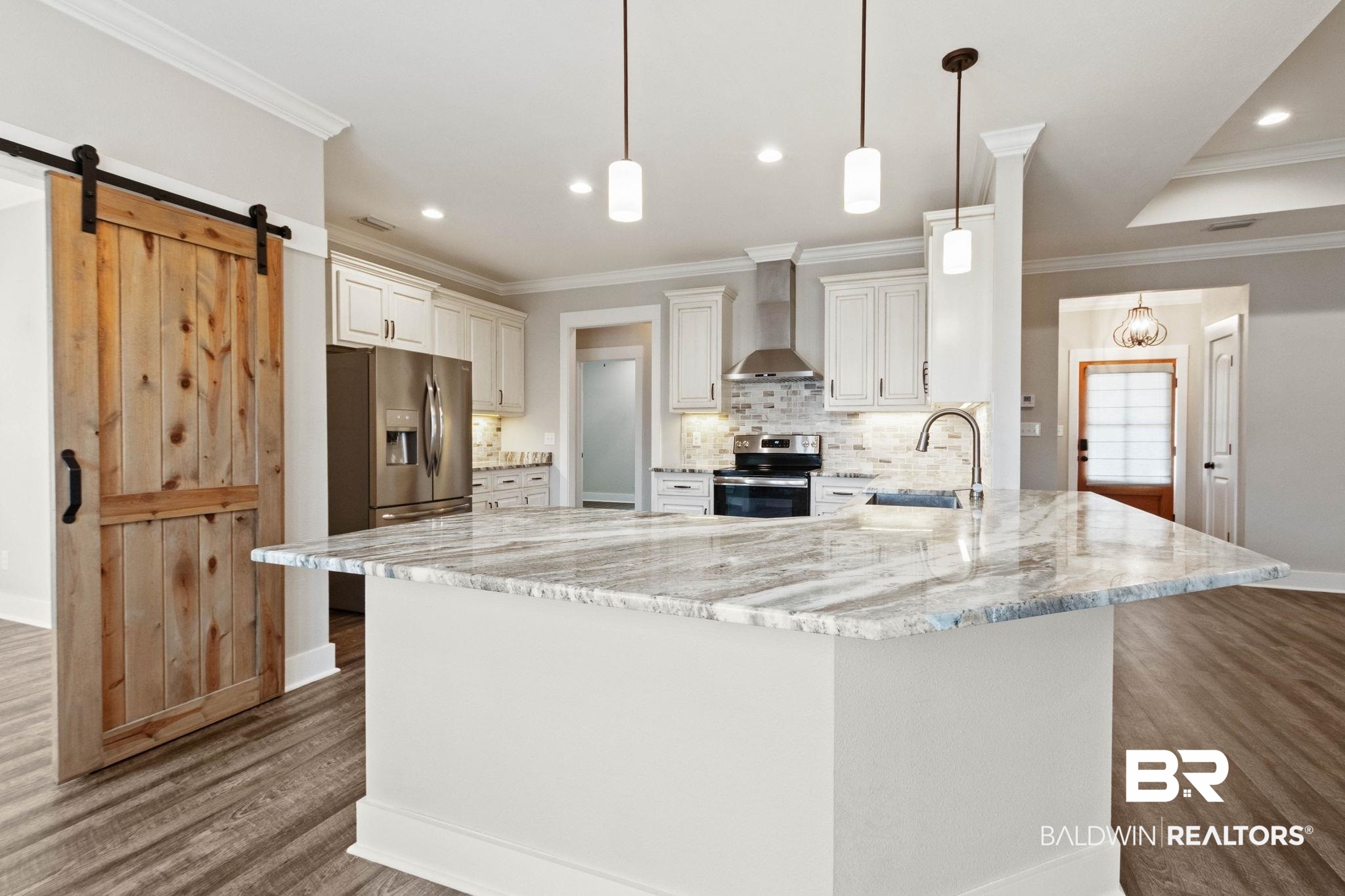17376 Bankhead Boulevard Fairhope, AL 36532 - Photo 19 of 73 Kitchen featuring a barn door, light stone countertops, appliances with stainless steel finishes, ornamental molding, and pendant lighting