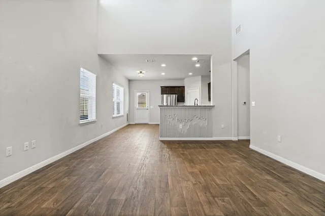 wooden floor in an empty room with a kitchen