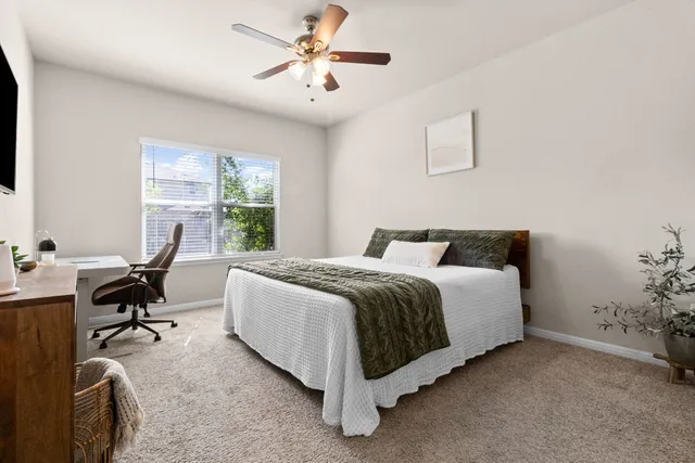 a spacious bedroom with a bed and a desk