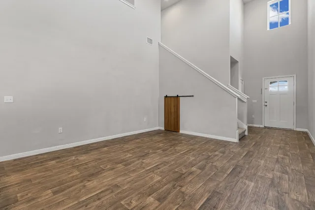 a view of empty room with wooden floor
