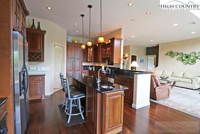 1352 West Deep Ford Road Lansing, NC 28643 - Photo 23 of 50 a kitchen with stainless steel appliances kitchen island granite countertop a stove a sink a refrigerator and a dining table with wooden floor