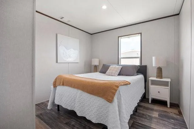 a bedroom with a bed and wooden floor